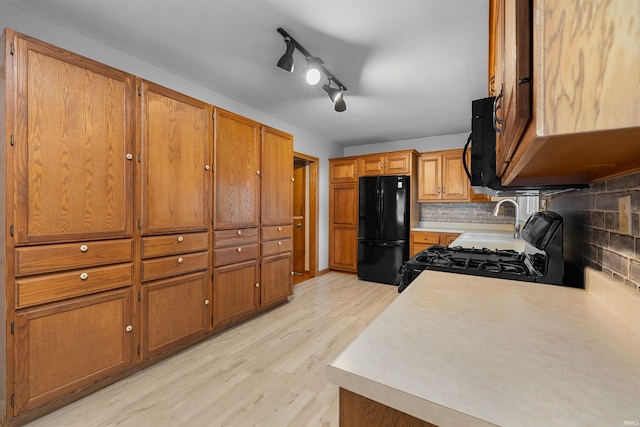 501 N Van Buren St, Auburn, IN 46706 - kitchen featuring black appliances, brown cabinets, light wood-style floors, and light countertops