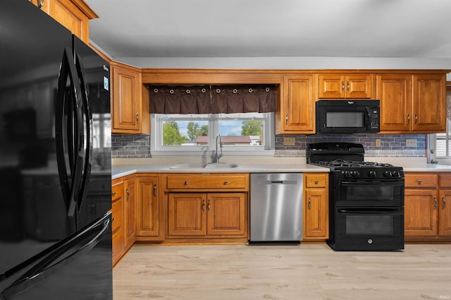 501 N Van Buren St, Auburn, IN 46706 - kitchen with black appliances, brown cabinets, tasteful backsplash, light countertops, and light wood-style flooring