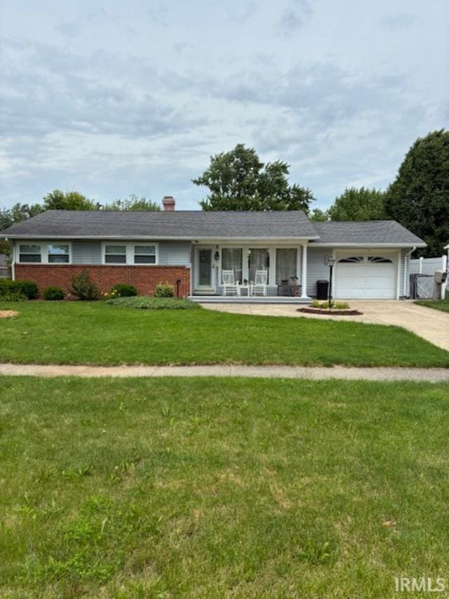 1814 W Kem Rd, Marion, IN 46952 - single story home featuring a garage, driveway, covered porch, and a chimney