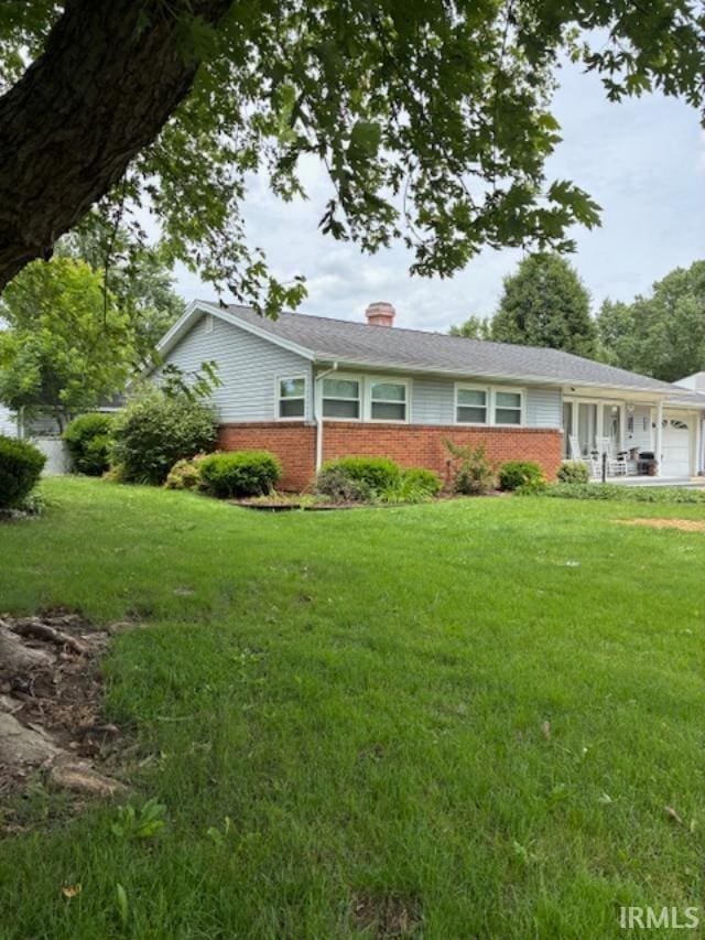 1814 W Kem Rd, Marion, IN 46952 - ranch-style house featuring brick siding, an attached garage, a chimney, and a front yard