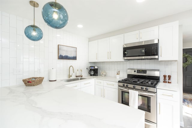 1621 E Madison St, South Bend, IN 46617 - kitchen featuring appliances with stainless steel finishes, tasteful backsplash, white cabinetry, light stone counters, and recessed lighting