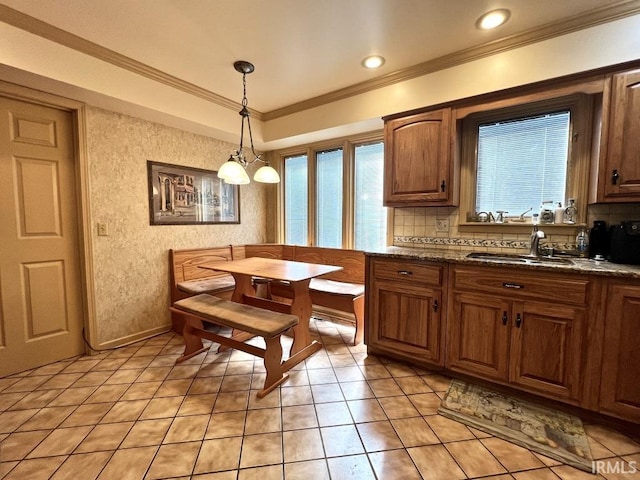 408 Duryea Dr, Auburn, IN 46706 - kitchen with ornamental molding, tasteful backsplash, light tile patterned floors, pendant lighting, and brown cabinetry