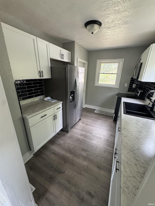 118 Burns Blvd, Fort Wayne, IN 46807 - kitchen with tasteful backsplash, white cabinets, a textured ceiling, and appliances with stainless steel finishes