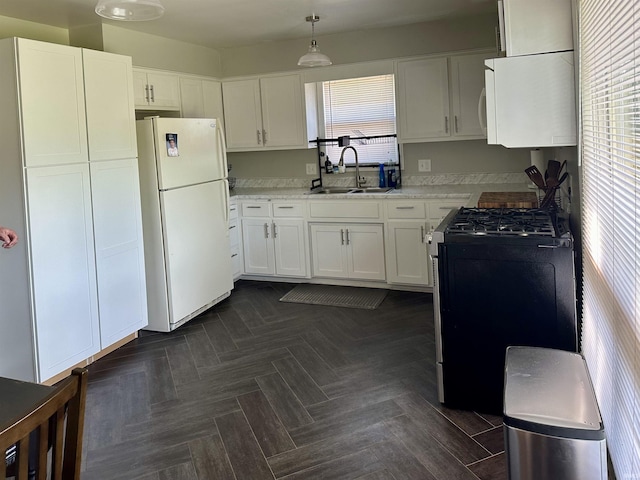 2407 Sherborne Blvd, Fort Wayne, IN 46805 - kitchen with freestanding refrigerator, gas range, white cabinets, light countertops, and decorative light fixtures