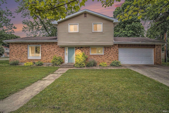 1822 Sherman Ave, South Bend, IN 46616 - tri-level home with concrete driveway, a garage, brick siding, and a lawn