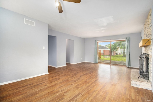 1822 Sherman Ave, South Bend, IN 46616 - unfurnished living room with a large fireplace, light wood-type flooring, and a ceiling fan