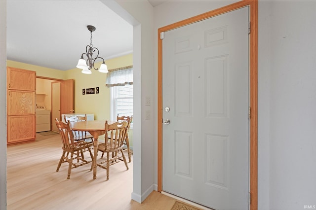 8620 Shearwater Pass, Fort Wayne, IN 46825 - dining space featuring washer / clothes dryer, light wood-type flooring, and a chandelier