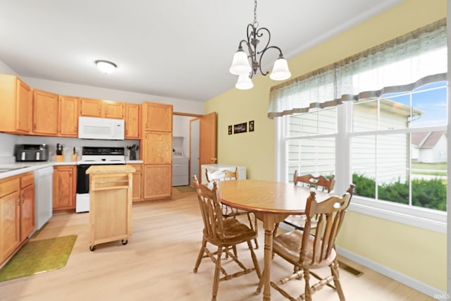 8620 Shearwater Pass, Fort Wayne, IN 46825 - dining room featuring washer / dryer, healthy amount of natural light, a chandelier, and light wood-style floors