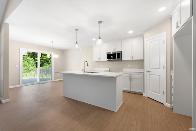 13969 Diavik Pl, Fort Wayne, IN 46845 - kitchen featuring stainless steel microwave, light wood finished floors, recessed lighting, white cabinets, and decorative light fixtures