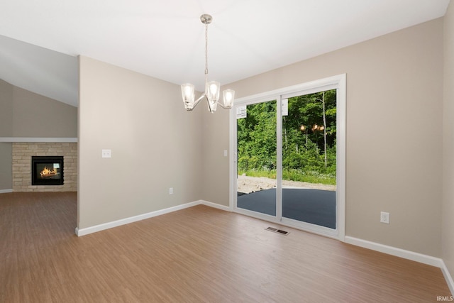 13969 Diavik Pl, Fort Wayne, IN 46845 - unfurnished room featuring wood finished floors, a chandelier, and a glass covered fireplace