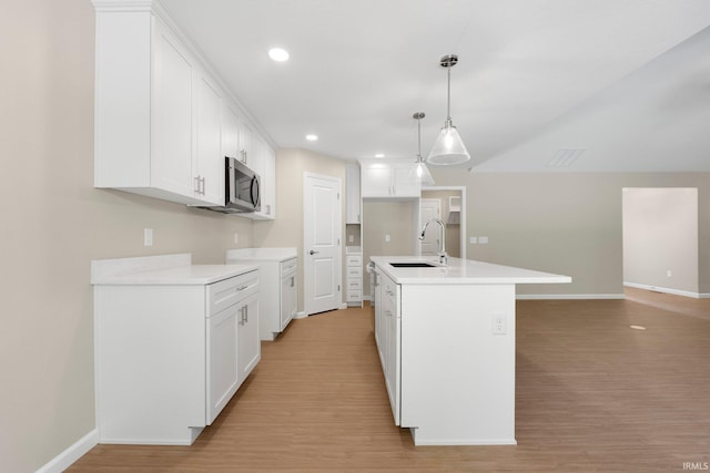 13969 Diavik Pl, Fort Wayne, IN 46845 - kitchen with light wood-style floors, stainless steel microwave, white cabinets, light countertops, and recessed lighting