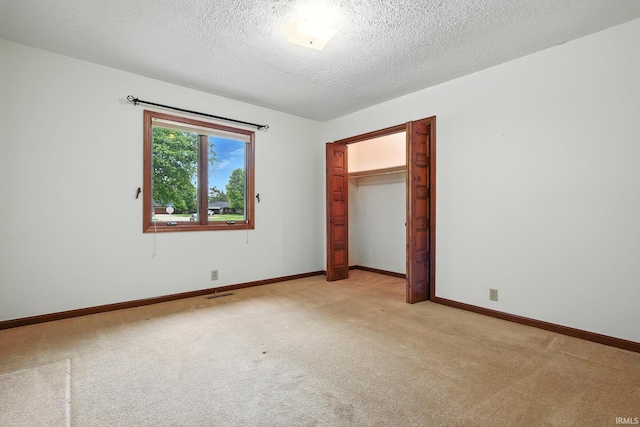 708 Forest Dr, Frankfort, IN 46041 - unfurnished bedroom with light colored carpet, a textured ceiling, and a closet