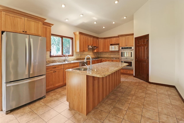 9932 N Meridian Line Rd, West Lafayette, IN 47906 - kitchen featuring appliances with stainless steel finishes, tasteful backsplash, a kitchen island with sink, vaulted ceiling, and light stone countertops