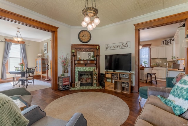 650 Main St, Rockport, IN 47635 - living area with dark wood-style floors, a fireplace, ornamental molding, a chandelier, and an ornate ceiling