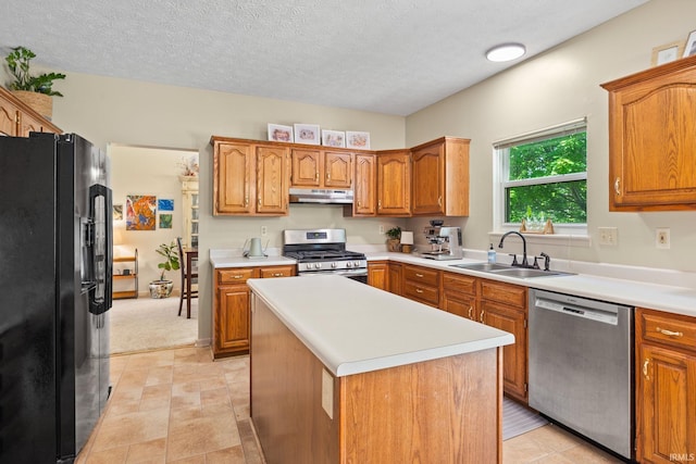 210 N Brookfield Dr, Lafayette, IN 47905 - kitchen with stainless steel appliances, under cabinet range hood, light countertops, brown cabinets, and a textured ceiling
