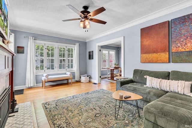 4721 Carrollton Ave, Indianapolis, IN 46205 - living room featuring a ceiling fan, crown molding, a fireplace with flush hearth, and wood finished floors