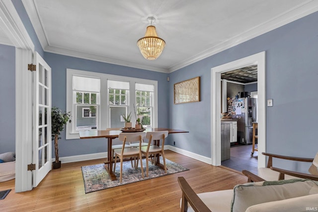 4721 Carrollton Ave, Indianapolis, IN 46205 - dining area featuring ornamental molding, a chandelier, and wood finished floors