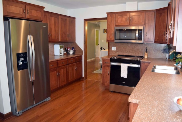 2020 N Red Bank Rd, Evansville, IN 47720 - kitchen featuring appliances with stainless steel finishes, tasteful backsplash, light wood-style floors, light countertops, and brown cabinetry