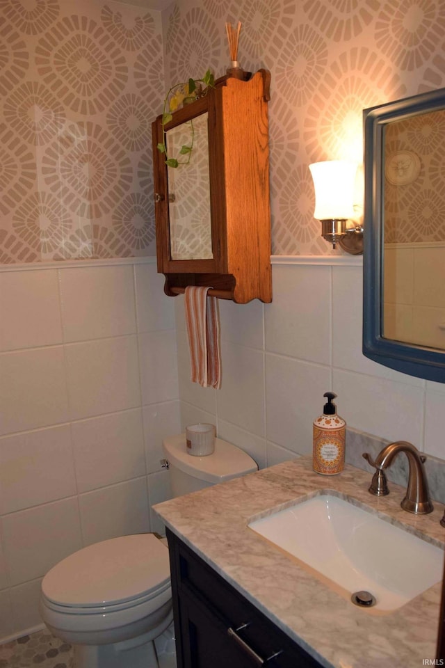 2020 N Red Bank Rd, Evansville, IN 47720 - half bathroom featuring tile walls, wallpapered walls, vanity, and a wainscoted wall