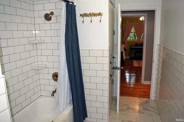 2020 N Red Bank Rd, Evansville, IN 47720 - full bath featuring tile walls, shower / tub combo with curtain, a wainscoted wall, and marble look tiles