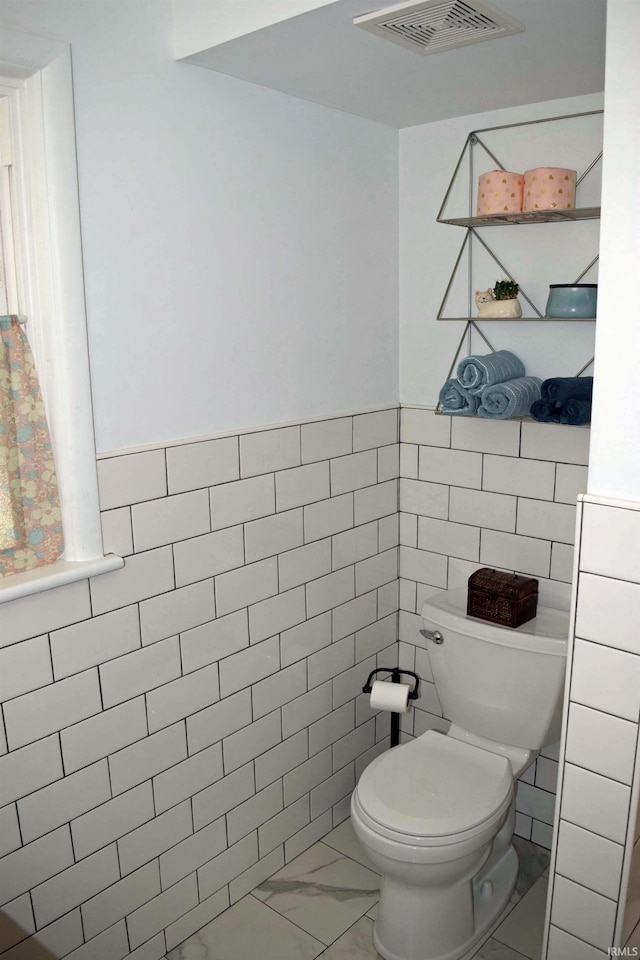 2020 N Red Bank Rd, Evansville, IN 47720 - bathroom with tile walls, marble finish flooring, and a wainscoted wall