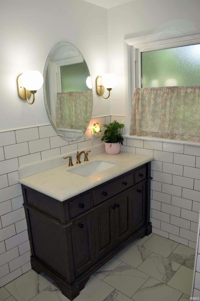 2020 N Red Bank Rd, Evansville, IN 47720 - bathroom with tile walls, marble look tile flooring, vanity, and a wainscoted wall