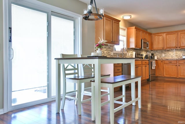 3517 Boulder Pass, Fort Wayne, IN 46818 - kitchen featuring stainless steel appliances, backsplash, dark wood-style flooring, a chandelier, and brown cabinetry
