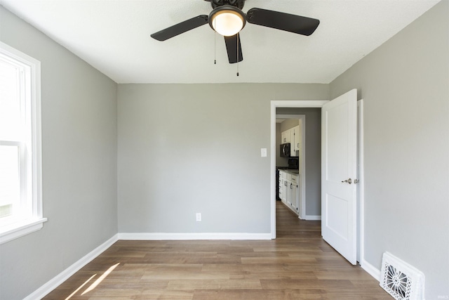 717 S Falcon St, South Bend, IN 46619 - empty room with light wood finished floors and a ceiling fan