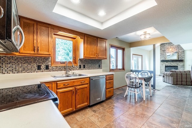 11215 Crested Oak Ct, Fort Wayne, IN 46845 - kitchen with appliances with stainless steel finishes, a fireplace, brown cabinetry, backsplash, and recessed lighting