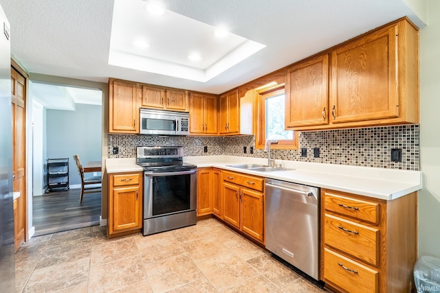 11215 Crested Oak Ct, Fort Wayne, IN 46845 - kitchen with appliances with stainless steel finishes, brown cabinets, decorative backsplash, light countertops, and recessed lighting