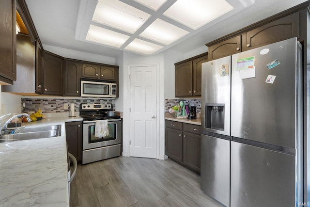 1936 Mark Anthony Xing, Fort Wayne, IN 46818 - kitchen featuring stainless steel appliances, decorative backsplash, dark brown cabinetry, and light wood-style flooring