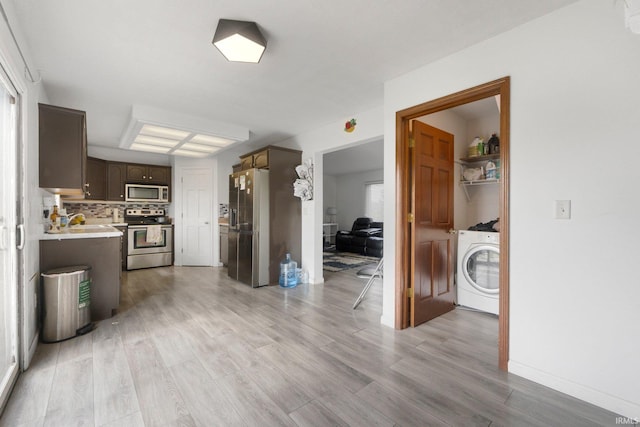 1936 Mark Anthony Xing, Fort Wayne, IN 46818 - kitchen with appliances with stainless steel finishes, washer / clothes dryer, light countertops, light wood-style flooring, and dark brown cabinets