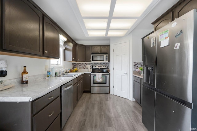 1936 Mark Anthony Xing, Fort Wayne, IN 46818 - kitchen with stainless steel appliances, dark brown cabinetry, light wood-style flooring, backsplash, and light countertops