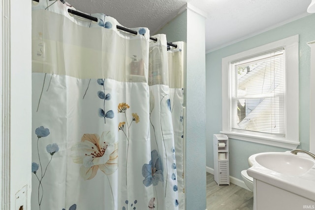 309 E Eckman St, South Bend, IN 46614 - bathroom with wood finished floors, vanity, ornamental molding, a shower with shower curtain, and a textured ceiling