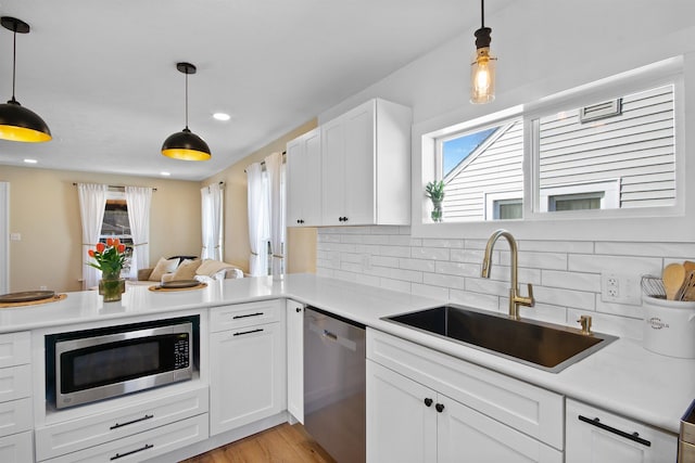 54054 N Ironwood Rd, South Bend, IN 46635 - kitchen with appliances with stainless steel finishes, decorative backsplash, light countertops, white cabinetry, and light wood-style flooring