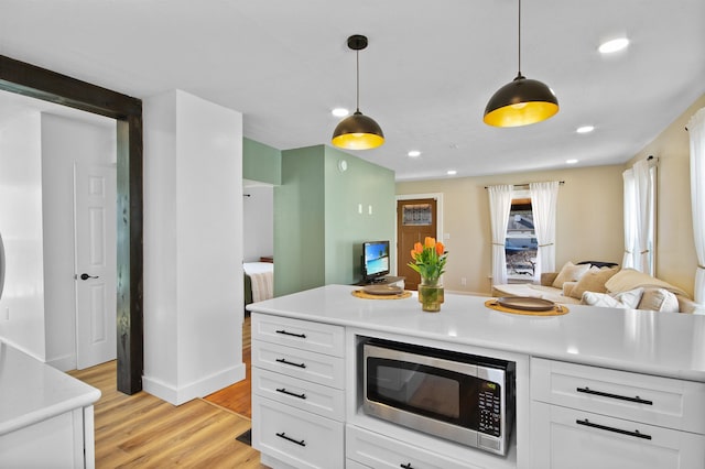 54054 N Ironwood Rd, South Bend, IN 46635 - kitchen featuring stainless steel microwave, light countertops, light wood finished floors, white cabinets, and recessed lighting