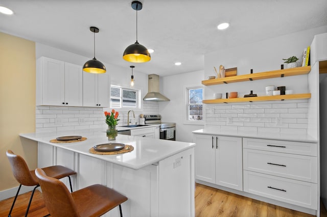 54054 N Ironwood Rd, South Bend, IN 46635 - kitchen featuring wall chimney exhaust hood, stainless steel electric range oven, a kitchen breakfast bar, decorative backsplash, and light countertops