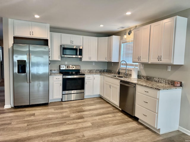 391 Hel Mar Dr, Mitchell, IN 47446 - kitchen with appliances with stainless steel finishes, light stone counters, white cabinetry, light wood-style floors, and recessed lighting