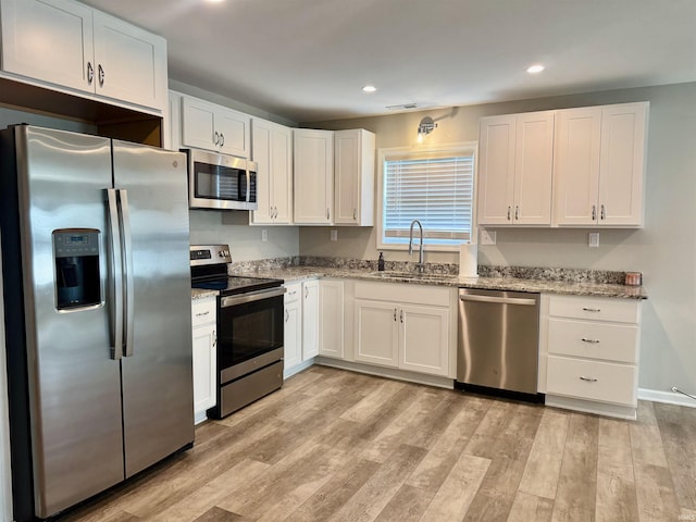 391 Hel Mar Dr, Mitchell, IN 47446 - kitchen featuring appliances with stainless steel finishes, recessed lighting, light stone countertops, white cabinets, and light wood-type flooring