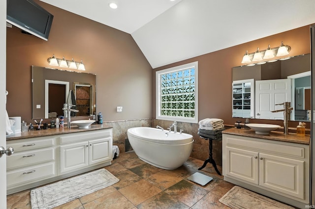 17325 N State Road 1st Rd, Spencerville, IN 46788 - full bath with tile walls, two vanities, a wainscoted wall, a freestanding tub, and high vaulted ceiling