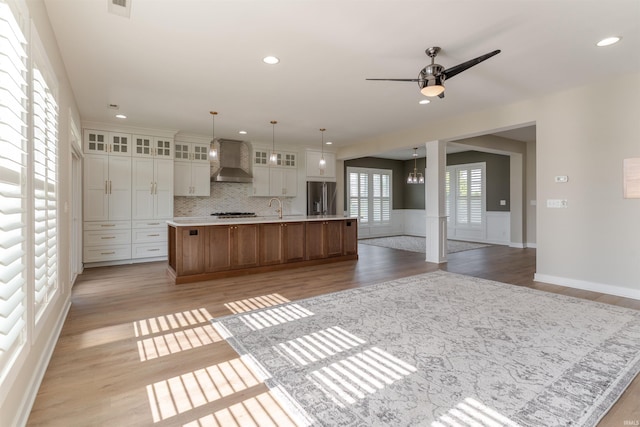 2843 Alex Ct, Newburgh, IN 47630 - kitchen featuring wall chimney exhaust hood, high quality fridge, a large island, light wood-style flooring, and glass insert cabinets