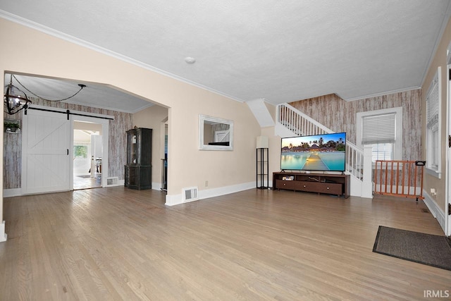 133 Crescent St, Elkhart, IN 46516 - living room featuring a barn door, wood finished floors, ornamental molding, wallpapered walls, and a textured ceiling