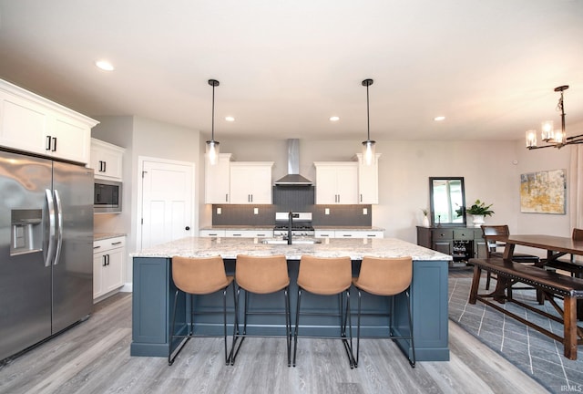 5358 Maize Dr, West Lafayette, IN 47906 - kitchen featuring stainless steel appliances, wall chimney range hood, light wood finished floors, a center island with sink, and recessed lighting