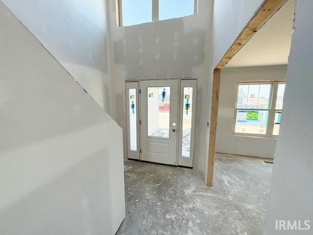 13315 Halen Hill Ct, Fort Wayne, IN 46818 - entrance foyer featuring plenty of natural light, a high ceiling, and unfinished concrete floors