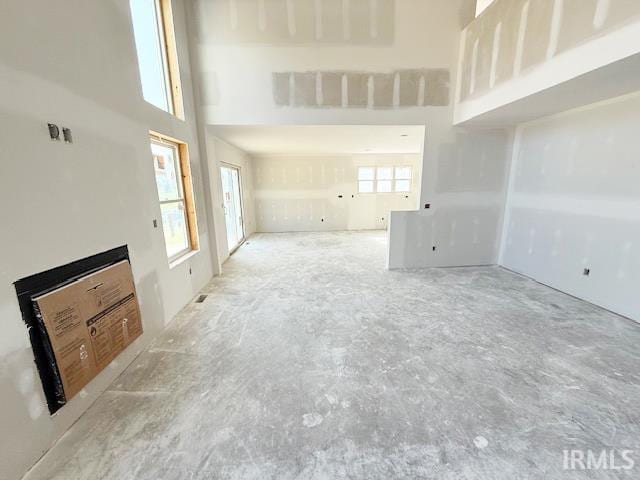 13315 Halen Hill Ct, Fort Wayne, IN 46818 - unfurnished living room featuring a towering ceiling and concrete floors