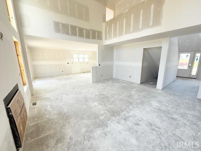 13315 Halen Hill Ct, Fort Wayne, IN 46818 - unfurnished living room featuring concrete floors and a high ceiling
