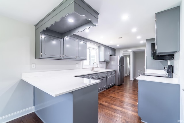 6321 Butt Rd, Fort Wayne, IN 46818 - kitchen featuring freestanding refrigerator, range, a peninsula, gray cabinetry, and dark wood finished floors