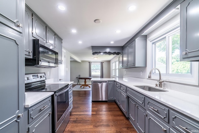 6321 Butt Rd, Fort Wayne, IN 46818 - kitchen with appliances with stainless steel finishes, gray cabinetry, recessed lighting, dark wood finished floors, and a peninsula