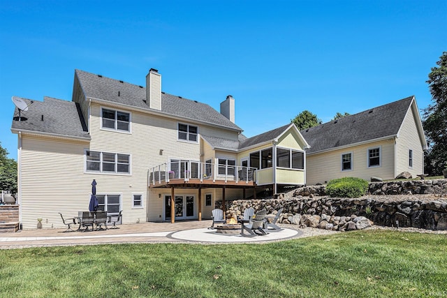 8196 E Walnut Rdg, New Carlisle, IN 46552 - rear view of house featuring a fire pit, a patio, a sunroom, a chimney, and a lawn
