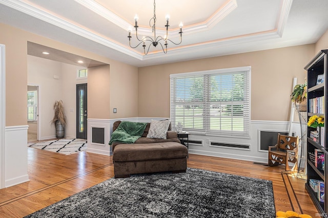 8196 E Walnut Rdg, New Carlisle, IN 46552 - sitting room with crown molding, a raised ceiling, a chandelier, wood finished floors, and a wainscoted wall